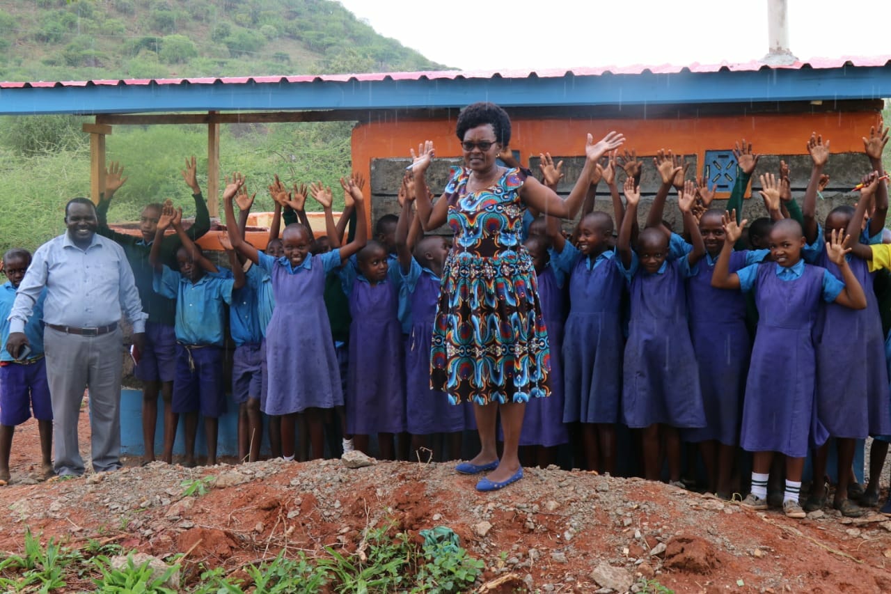 Headmistress standing with pupils having happily infant of their school